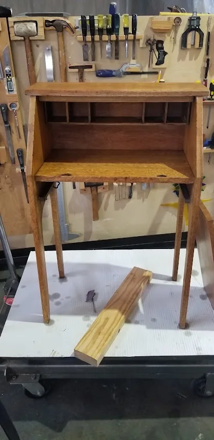 Fire-scorched solid-oak secretary desk before hinge repair, sanding, and refinishing.