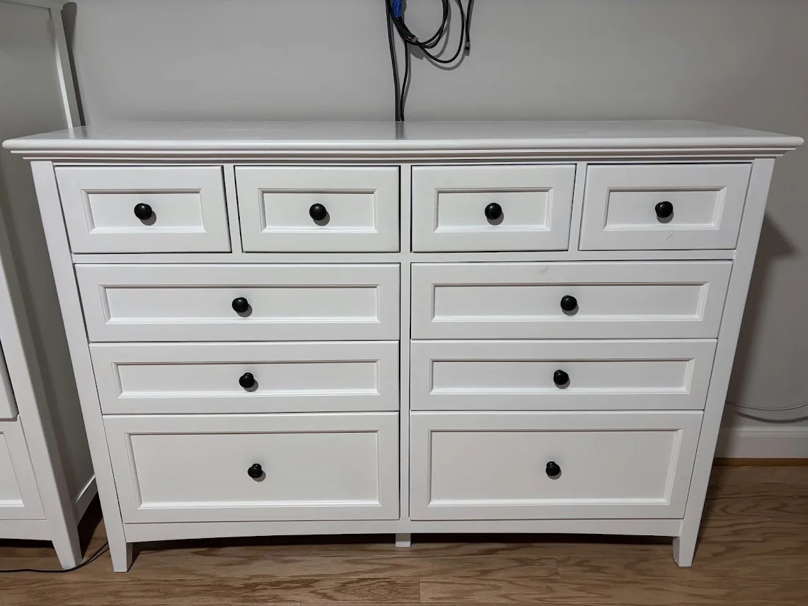 The fully restored, perfectly aligned white ten-drawer chest standing on a wood floor.